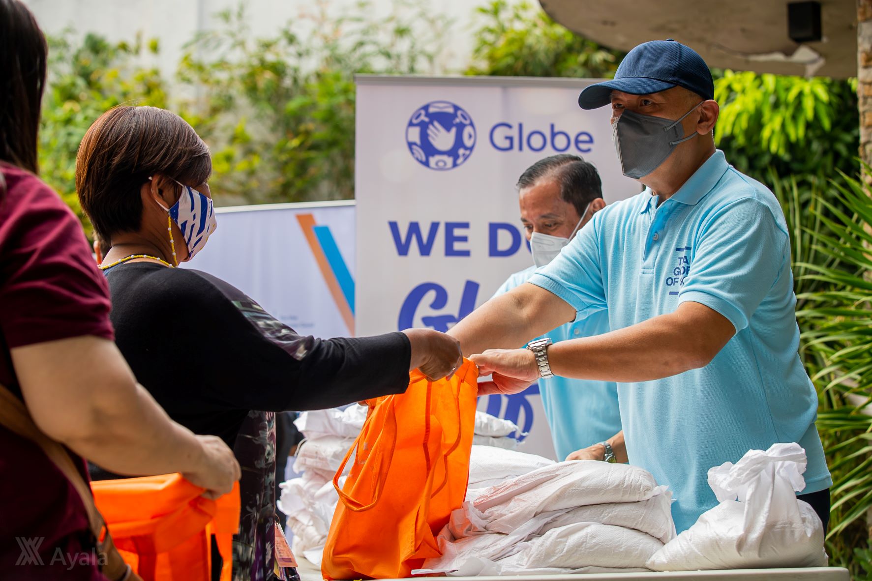 Globe Chief Executive Officer Ernest Cu distributes goods to beneficiaies in Mandaluyong alongside partners from Ayala Corporation's #BrigadangAyalaKaakay